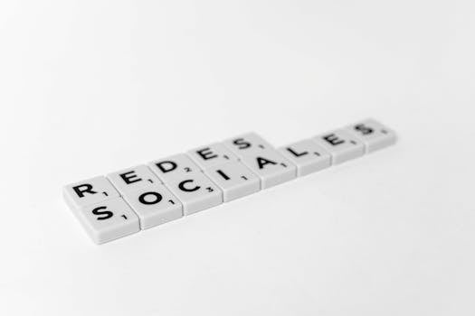 White Scrabble tiles arranged to spell 'Redes Sociales' on a plain background.